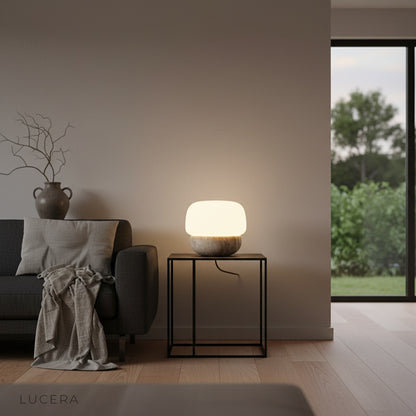 Close-up of travertine texture and softly glowing glass shade on Jut Table Lamp