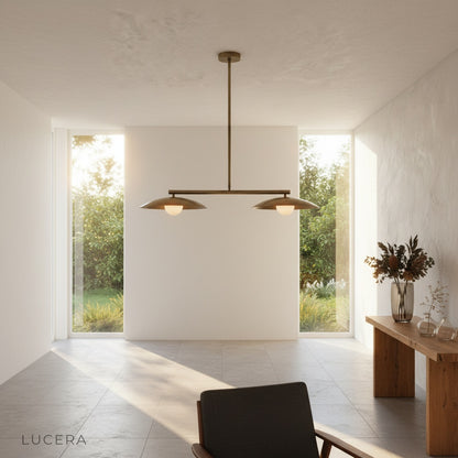 Overhead lifestyle view of the sculptural disc pendant above a rustic wooden table with decor