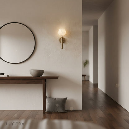 Madeira wall lamp casting ambient light in a cozy reading nook with textured plaster wall