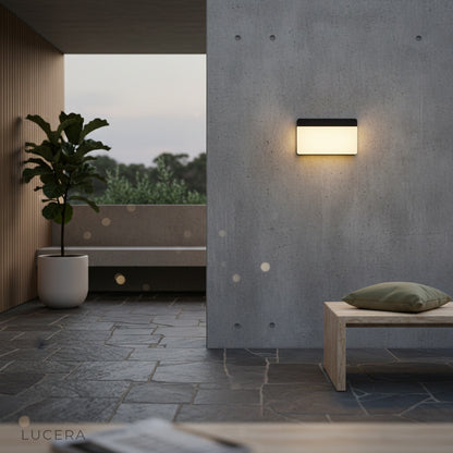 black and white outdoor sconce lighting up a modern garden pathway
