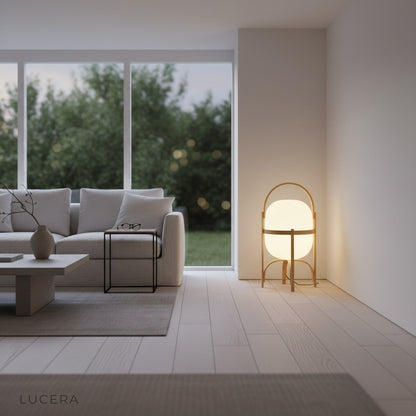 Aureolin table lamp glowing warmly on a wooden desk with books and laptop in a modern home office at dusk