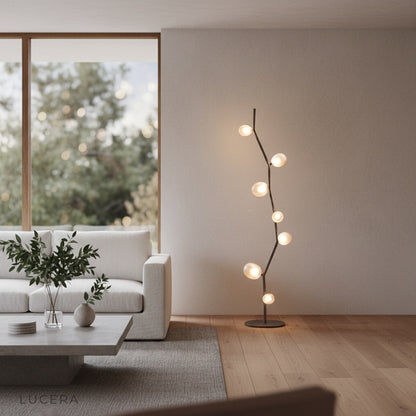 Lucera Dahlia floor lamp with zig-zag frame beside a neutral sofa in daylight