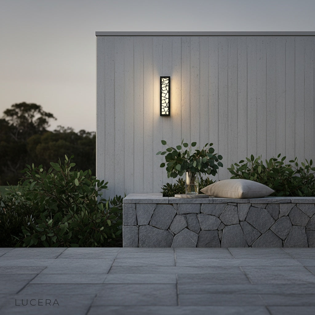 Emblem Wall Lamp mounted on a brick wall near a stylish outdoor dining table