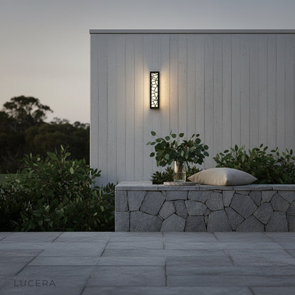 Emblem Wall Lamp mounted on a brick wall near a stylish outdoor dining table