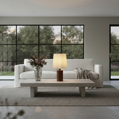 Nighttime lifestyle shot of Pandora Table Lamp on entryway table with stone wall background and warm inviting glow