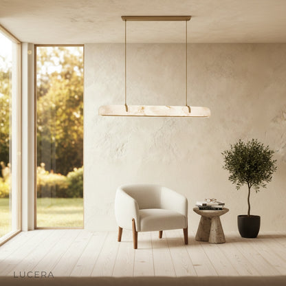 Nerissa chandelier above a marble kitchen island with copper accents and pendant lights