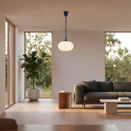 Xanthous pendant light at night with visible cable length above bedside table