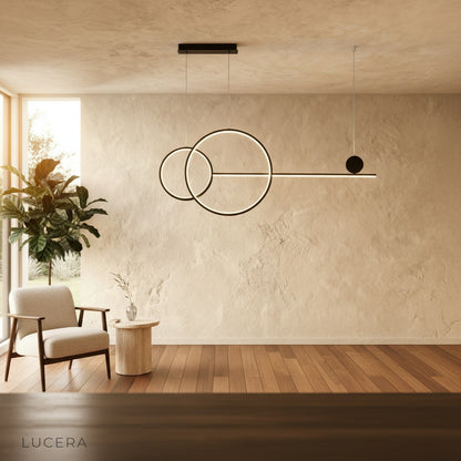 Brumal pendant light black rings glowing against dark wall in nighttime setting