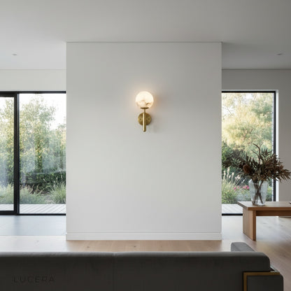 alabaster wall lamp illuminating dark hallway with sculptural silhouette and warm halo