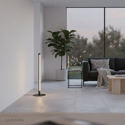 Pascal Table Lamp glowing in a dim hallway, highlighting its slim silhouette and circular base