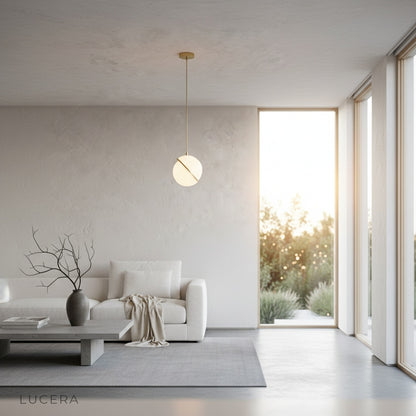 Igneous pendant light in hallway with polished brass finish and white sphere