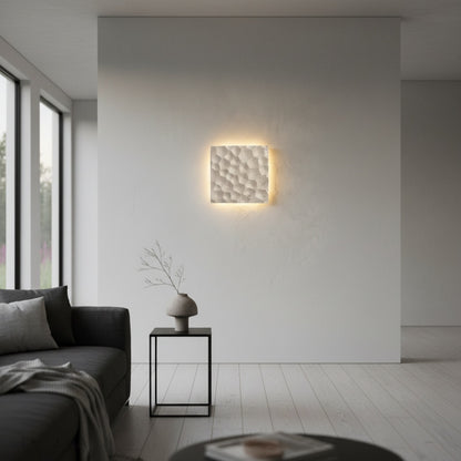 Wampum travertine wall lamp illuminated at night in contemporary lounge