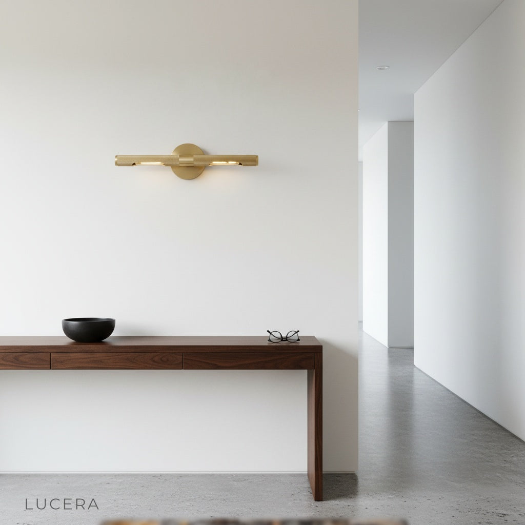 Keziah brass mirror light styled in cozy bedroom corner with warm brass tones