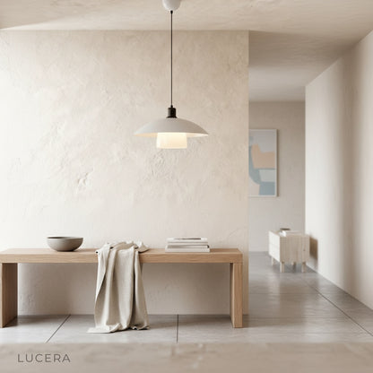Eburnean pendant light in dark interior with warm light and shadow play on wall