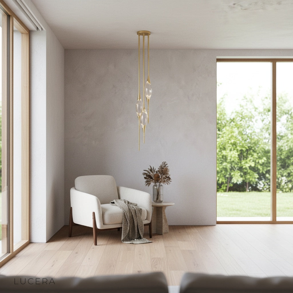 pair of Indus pendant lights in brushed gold hanging at different heights in elegant entryway