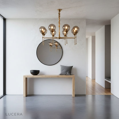 Erbaluce chandelier hanging over kitchen island with pendant globes illuminated