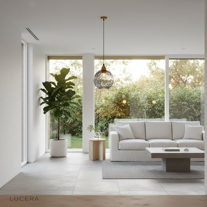 Kronos pendant light hanging over kitchen island in evening, gold highlights reflecting