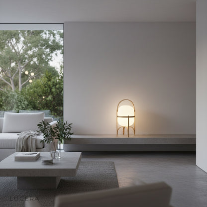 Aureolin portable lamp casting ambient light on a rattan chair in a sunlit reading corner with plants