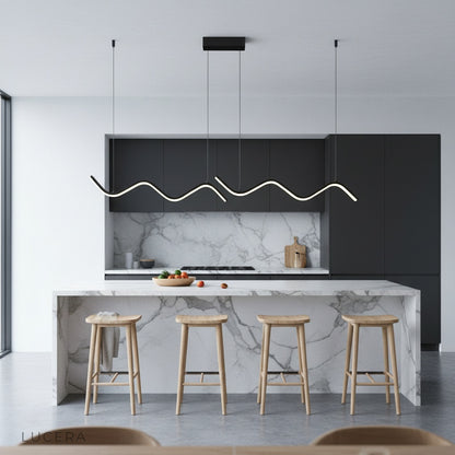 adjustable Melisande pendant light hanging over a minimalist kitchen island
