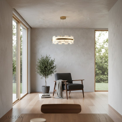 Ablution chandelier hanging in a minimalist dining room with warm light reflecting on wooden table