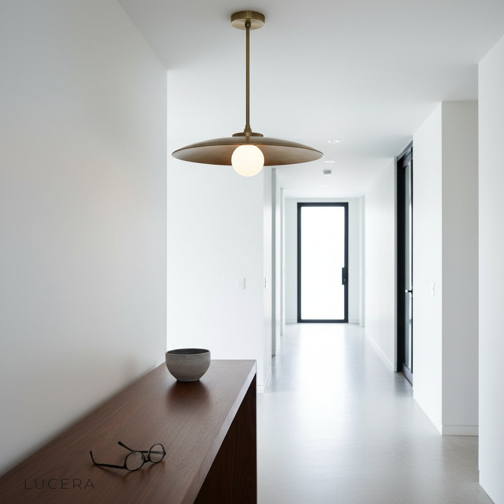 Sylvaine pendant light glowing at night above a stylish table with chairs