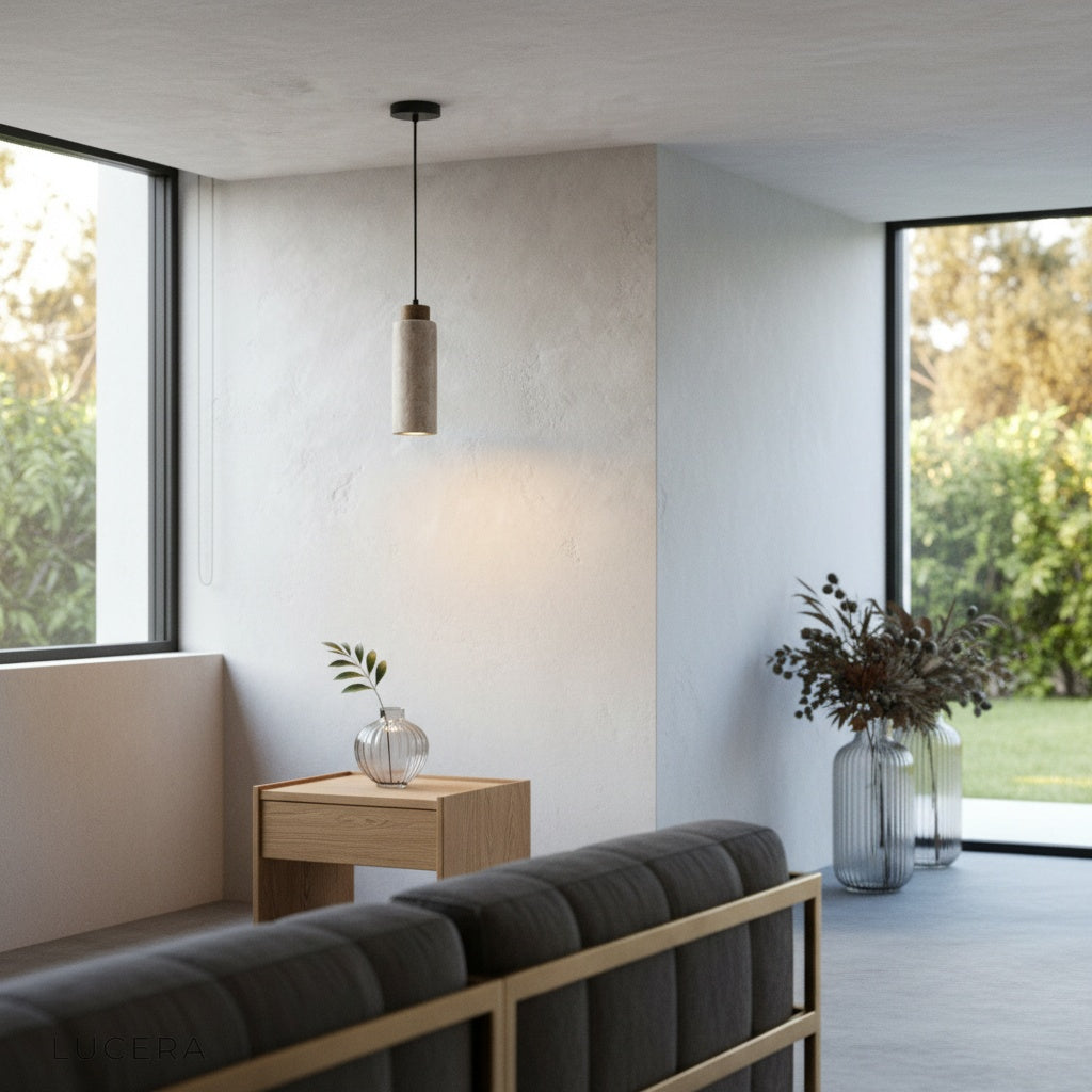Nighttime lifestyle shot of Clandestine travertine pendant light illuminating a minimalist entryway with concrete floor