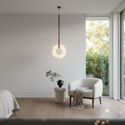 Helix alabaster pendant light illuminated at night above rustic wooden table in farmhouse dining room