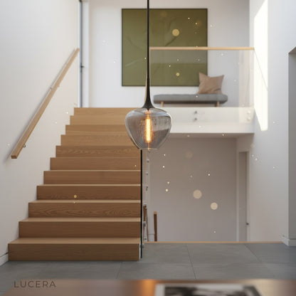Teardrop seeded glass pendant light glowing in minimalist bedroom corner at night