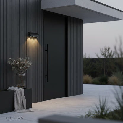three-light Elaxi wall lamp in nighttime patio setting with ambient lighting